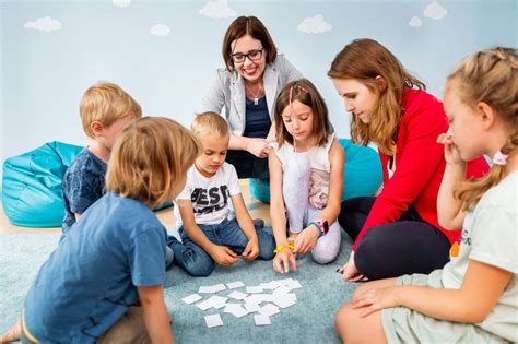 Zdjęcie przedstawiające nauczycielkę pracującą z dziećmi przy użyciu materiałów edukacyjnych.