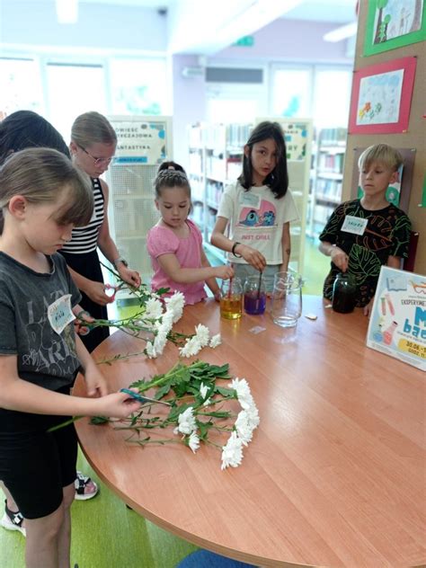 Dzieci sadzące kwiaty w słoikach podczas warsztatów