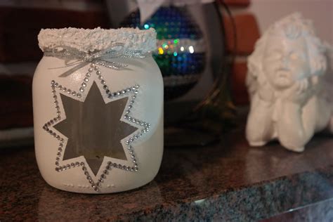 Ilustracja przedstawiająca własnoręcznie wykonany lampion adwentowy ze słoika, ozdobiony gałązkami świerku i suszonymi plastrami pomarańczy.