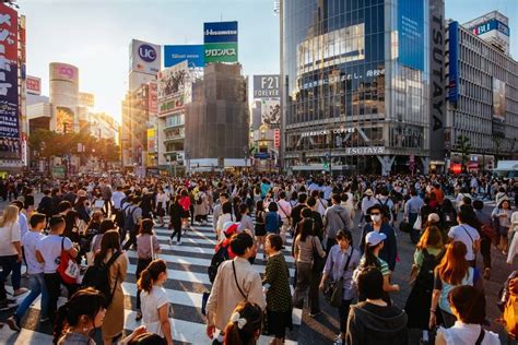 zdjęcie tłumu ludzi w kostiumach na skrzyżowaniu Shibuya w Tokio podczas Halloween