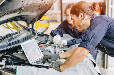 zdjęcie mechanika pracującego przy silniku samochodu w warsztacie