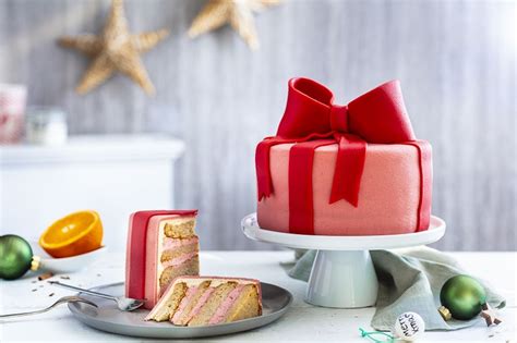 zdjęcie gotowego tortu prezent z kokardką, ozdobionego pastelową marcepanową kokardką i wstążkami