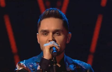 Portret Damiana Kuleja, lidera zespołu Diament, z mikrofonem w ręku