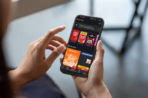 Ilustracja przedstawiająca smartfon z otwartą aplikacją API MARKET, na ekranie widoczne ikony promocji i zbierania punktów.