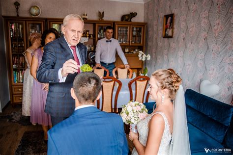 Ilustracja przedstawiająca błogosławieństwo dziecka przez rodziców, chrzestnych i dziadków przed wyjściem do kościoła.