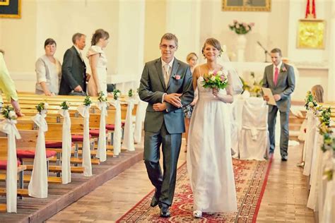 Para młoda trzymająca się za ręce podczas ceremonii ślubnej