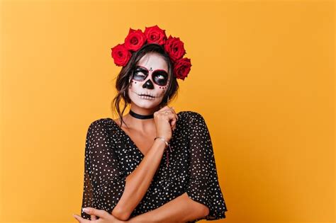 Kobieta z kreatywnym makijażem na Halloween, pełnym brokatu i nietypowych elementów.