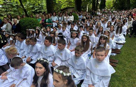 fotografia przedstawiająca uroczystość kościelną z dziećmi w strojach komunijnych