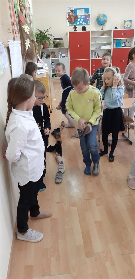 Dzieci ustawiające buty w kolejce podczas zabawy andrzejkowej.