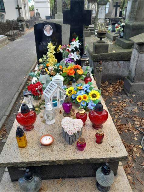 zdjęcie grobu Ireny Jarockiej na Powązkach, z widocznymi zniczami i kwiatami
