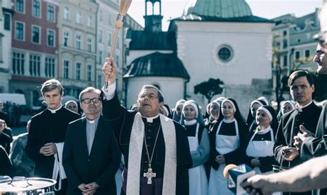 Zdjęcie grupowe księży w sutannach podczas uroczystości kościelnej