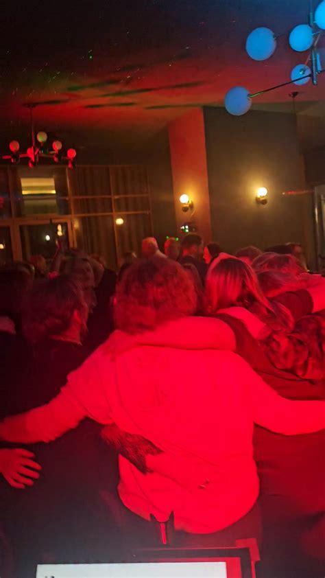zdjęcie z sali balowej z gośćmi bawiącymi się przy muzyce
