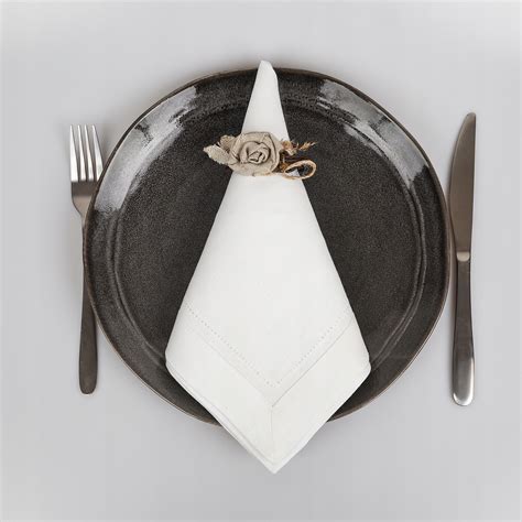 Elegancka, materiałowa serwetka złożona obok talerza