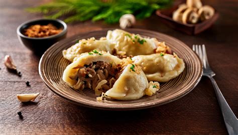zdjęcie talerza z pierogami z kapustą i grzybami, udekorowanymi smażoną cebulką