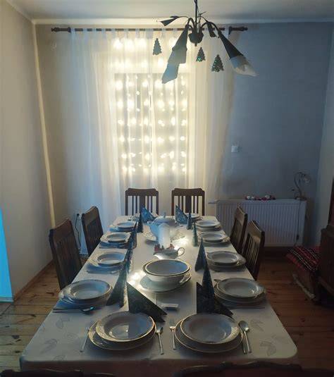 Zdjęcie przedstawiające stół udekorowany halloweenowym obrusem i mini-lampionami z pomarańczy.