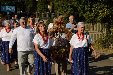schematyczny korowód dożynkowy z pocztami sztandarowymi i wieńcami