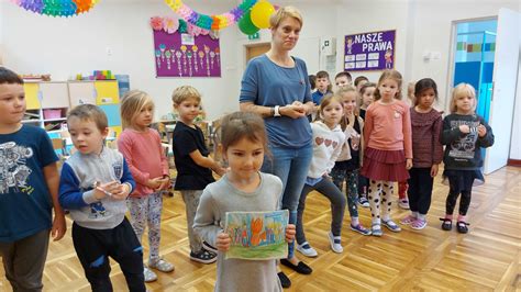 Ilustracja przedstawiająca animatora bawiącego się z grupą dzieci na tle weselnej sali.