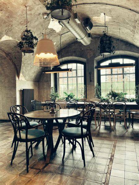 Wnętrze restauracji Dziurka od Klucza z ceglanymi ścianami i łukowymi sklepieniami.