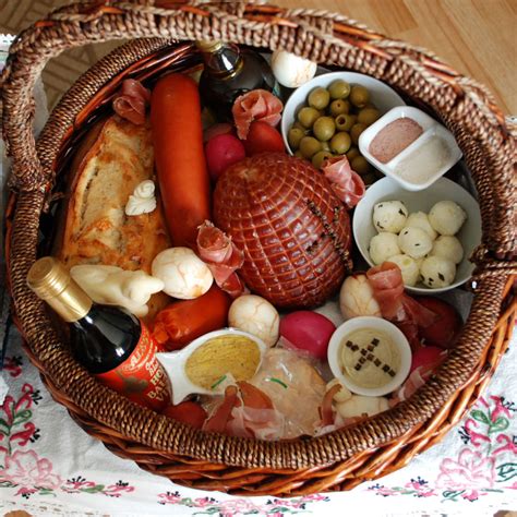 Udekorowany koszyk z tradycyjnymi polskimi pokarmami wielkanocnymi: jajka, chleb, kiełbasa, baranek.