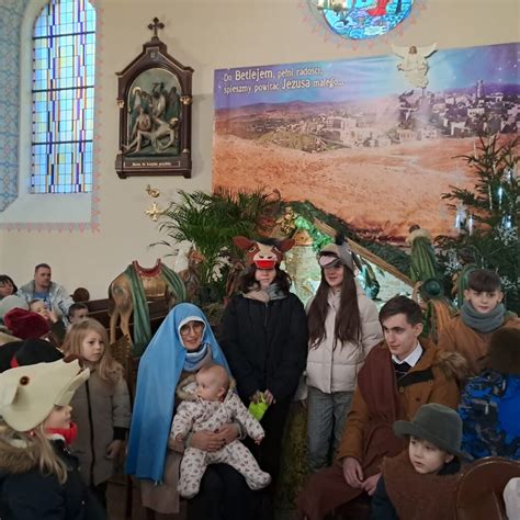 Grafika przedstawiająca zakonnice klęczące przy żłóbku.