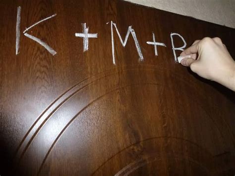 Zdjęcie kredy i napisu K+M+B na drzwiach domu
