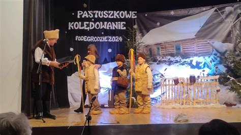 Ilustracja grupy kolędniczej w strojach pasterskich z tradycyjną szopką