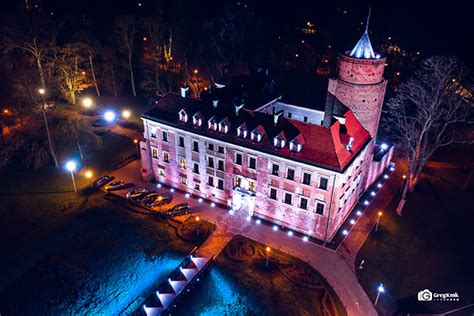 Widok na Zamek w Uniejowie nocą, oświetlony i otoczony sylwestrową atmosferą
