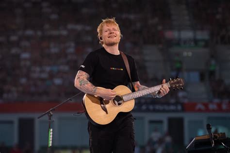 Ed Sheeran grający na gitarze podczas koncertu