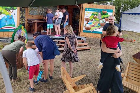Zdjęcie przedstawiające rodzinne atrakcje na dożynkach, np. malowanie twarzy dzieci lub stoisko z zabawkami