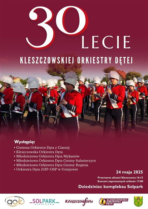 Zdjęcie uczestników balu karnawałowego orkiestry dętej w Uniejowie, bawiących się w eleganckich strojach.