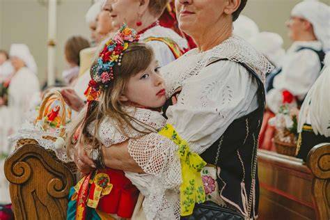fotografia przedstawiająca uczestników dożynek w barwnych strojach ludowych, tworzących korowód