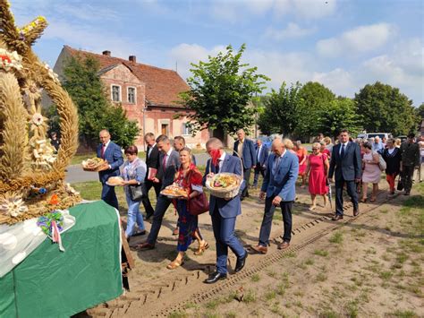 zdjęcie przedstawiające starostów dożynkowych przekazujących chleb staroście powiatu i burmistrzowi