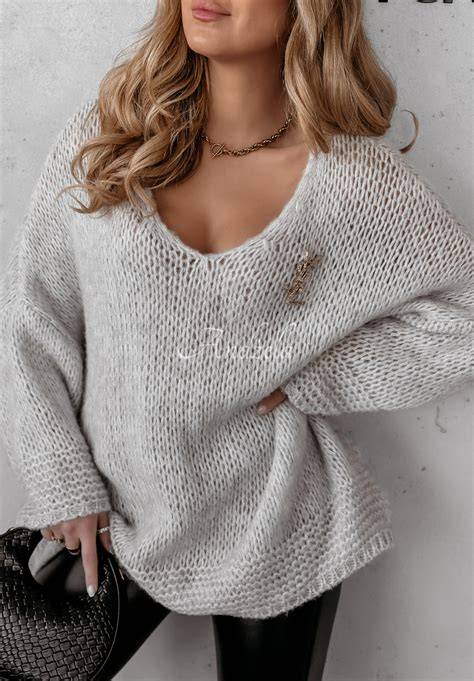 Modelka plus size prezentująca sweter oversize w jaskrawym kolorze, zestawiony z dopasowanymi spodniami.