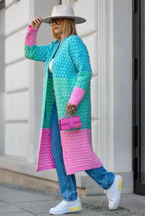 Stylizacja łącząca długi, kolorowy kardigan plus size z czarnymi jeansami i botkami.