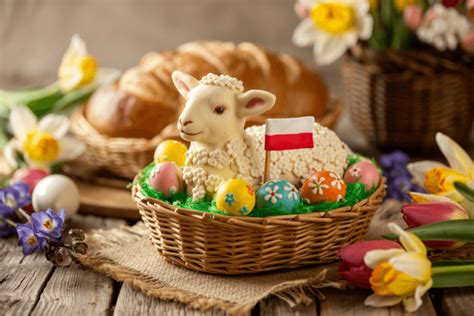 Ilustracja przedstawiająca typowe symbole wielkanocne: pisanki, baranek, zajączek i wiosenne kwiaty.