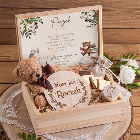 Drewniana skrzynia prezentowa z personalizowanymi przedmiotami na roczek.
