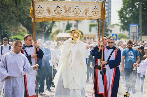 Tradycyjna procesja Bożego Ciała z dziewczynkami sypiącymi kwiaty i wiernymi z chorągwiami.
