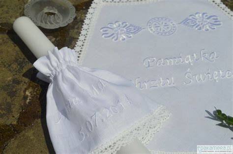 Zdjęcie przedstawiające komplet do chrztu: szatka i świeca