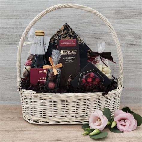 Zdjęcie eleganckiego kosza prezentowego wypełnionego różnymi słodyczami.