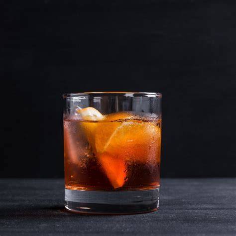 Szkło z drinkiem Old Fashioned udekorowane skórką pomarańczy