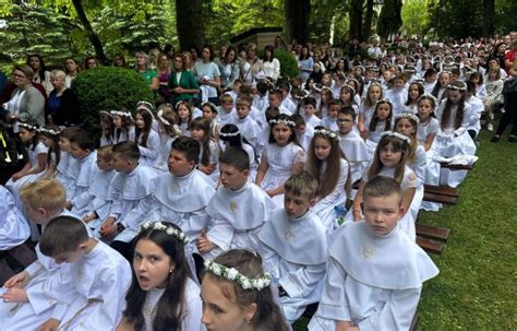 Zdjęcie dzieci w strojach komunijnych podczas mszy