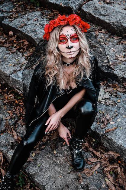 Kobieta z makijażem na Halloween w stylu zombie, prezentująca sztuczne rany i blade cera