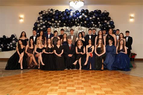 Grupa uczniów I Liceum Ogólnokształcącego w eleganckich strojach studniówkowych pozuje do wspólnego zdjęcia w Pałacu w Konarach.