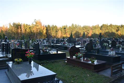 Zdjęcie cmentarza parafialnego w Kazimierzu Biskupim z nagrobkami i zielenią