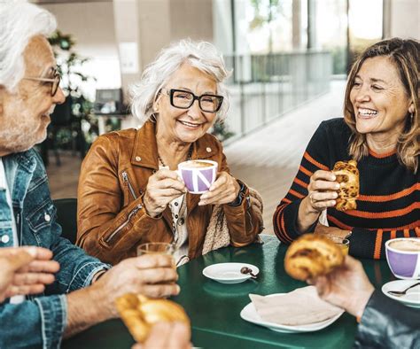 Grupa uśmiechniętych seniorów bawiących się na imprezie