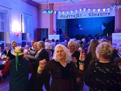 Fotografia przedstawiająca grupę seniorów bawiących się podczas imprezy andrzejkowej.