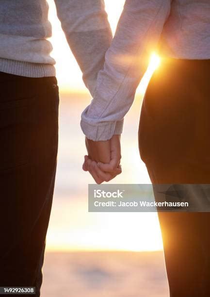 Zdjęcie pary trzymającej się za ręce podczas romantycznego spaceru w górach
