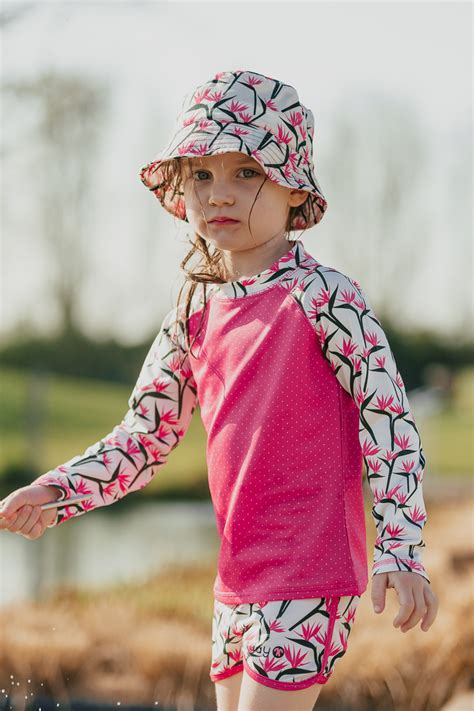 Zdjęcie niemowlaka ubranego w kombinezon kąpielowy z filtrem UV na plaży