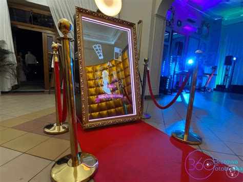 Eleganckie fotolustro z złotą ramą na tle sali weselnej