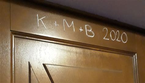 Napis K+M+B na drzwiach wejściowych, symbolizujący błogosławieństwo domu.